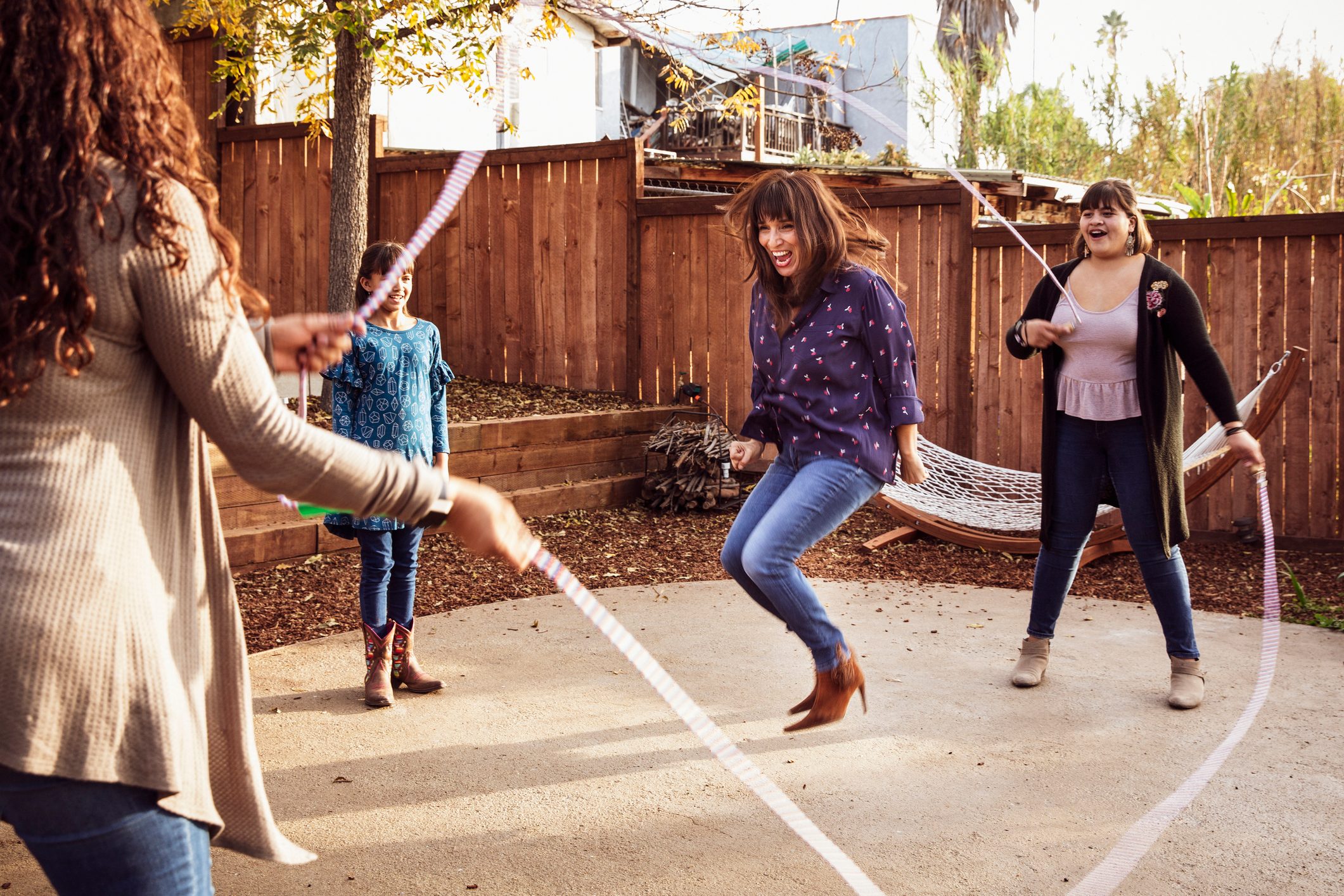 family playing jump rope outside