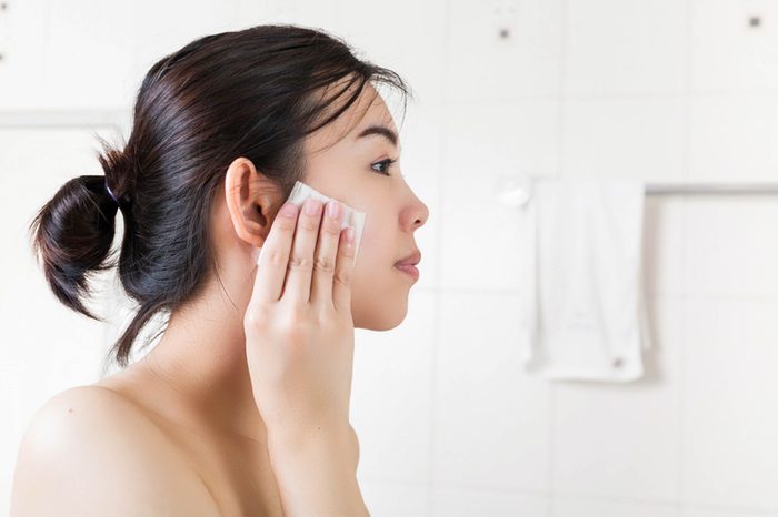 woman applying moisturizer to her face