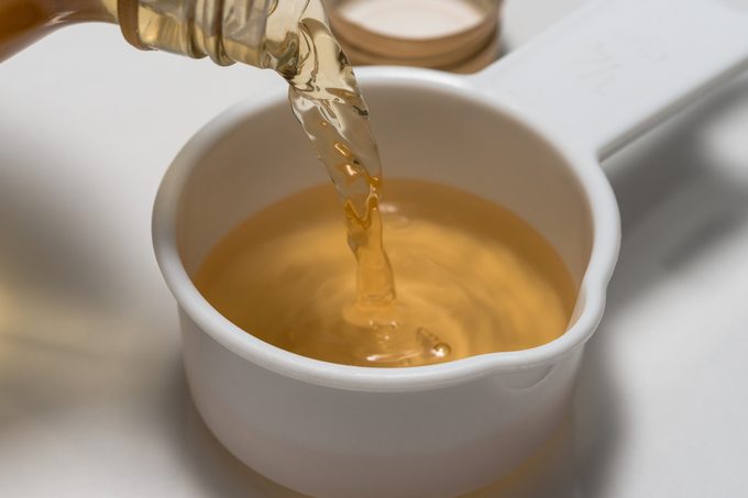 Pouring a quarter cup of apple cider vinegar