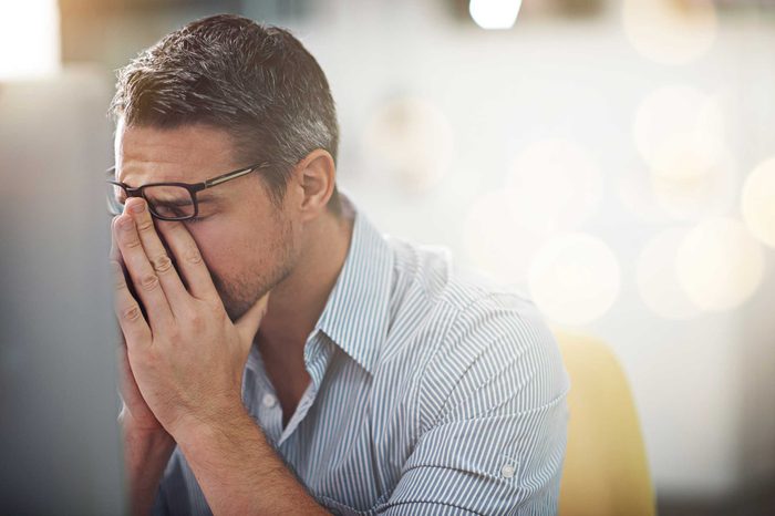 Stressed man putting his hands to his face