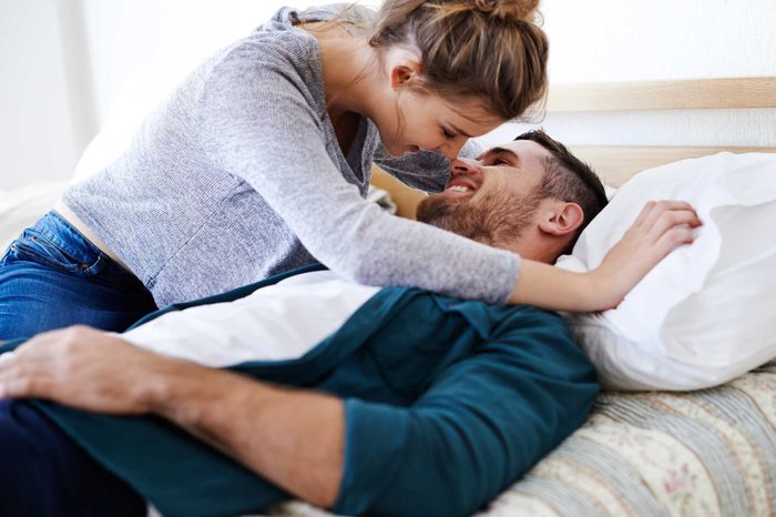 Woman kissing man in bed