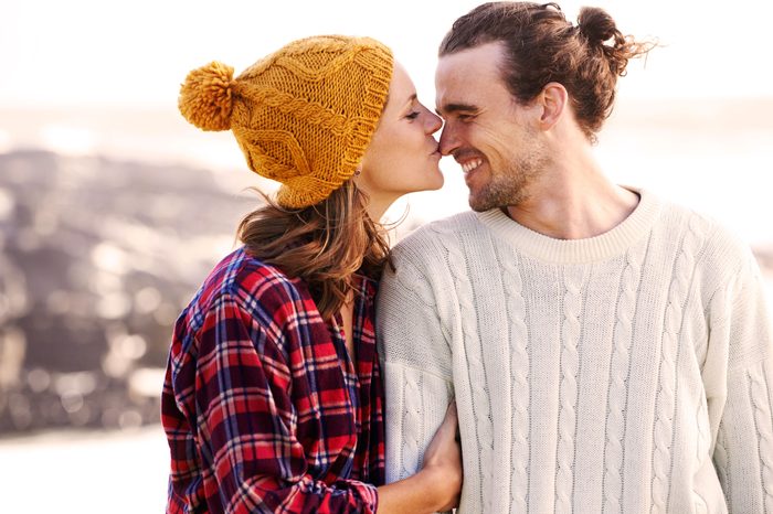 outdoorsy woman kissing man on the nose