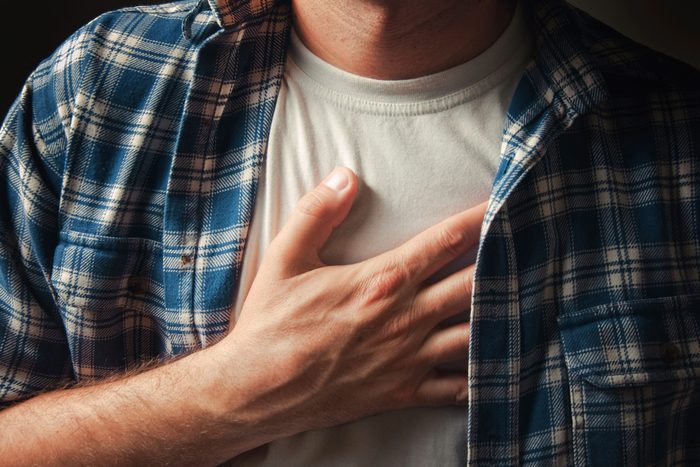 man with hand on chest