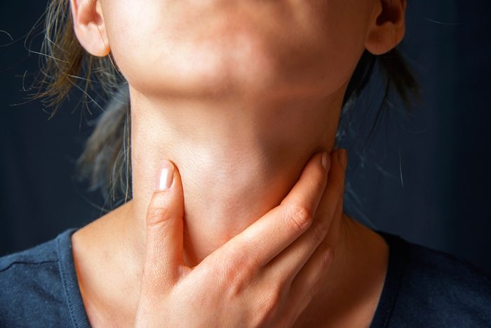 woman holding her throat