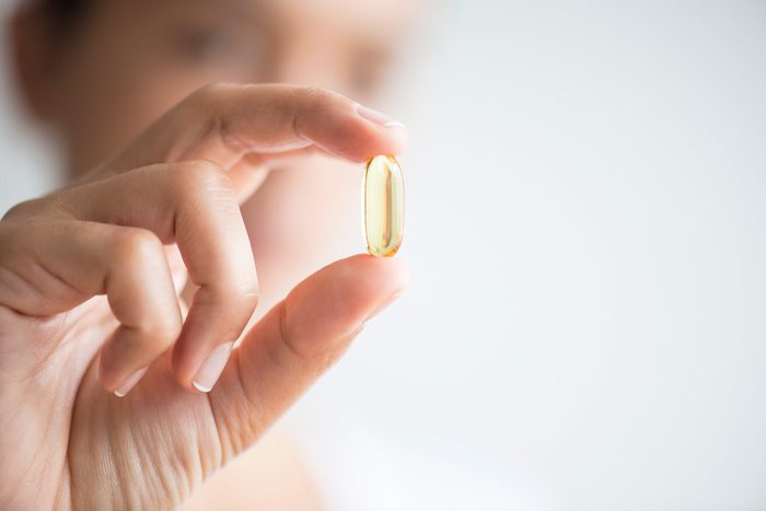 person holding a translucent capsule