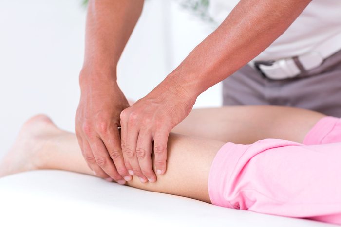 massage therapist working on patient's calf