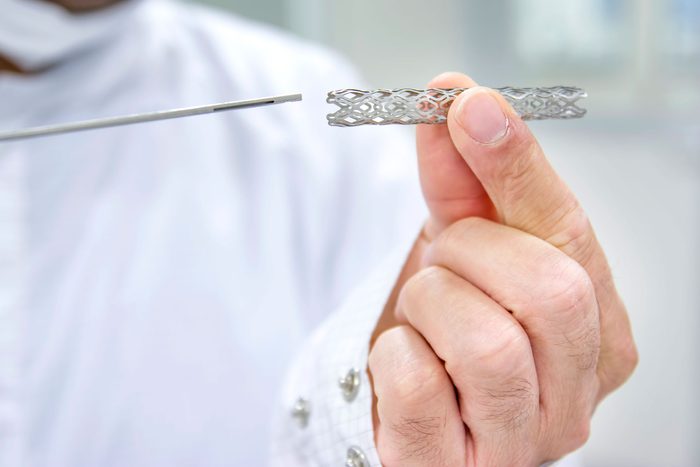 person holding metal stent