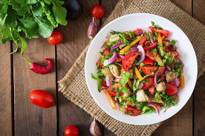 Plate of colorful veggies on a burlap placemat on a wooden table.