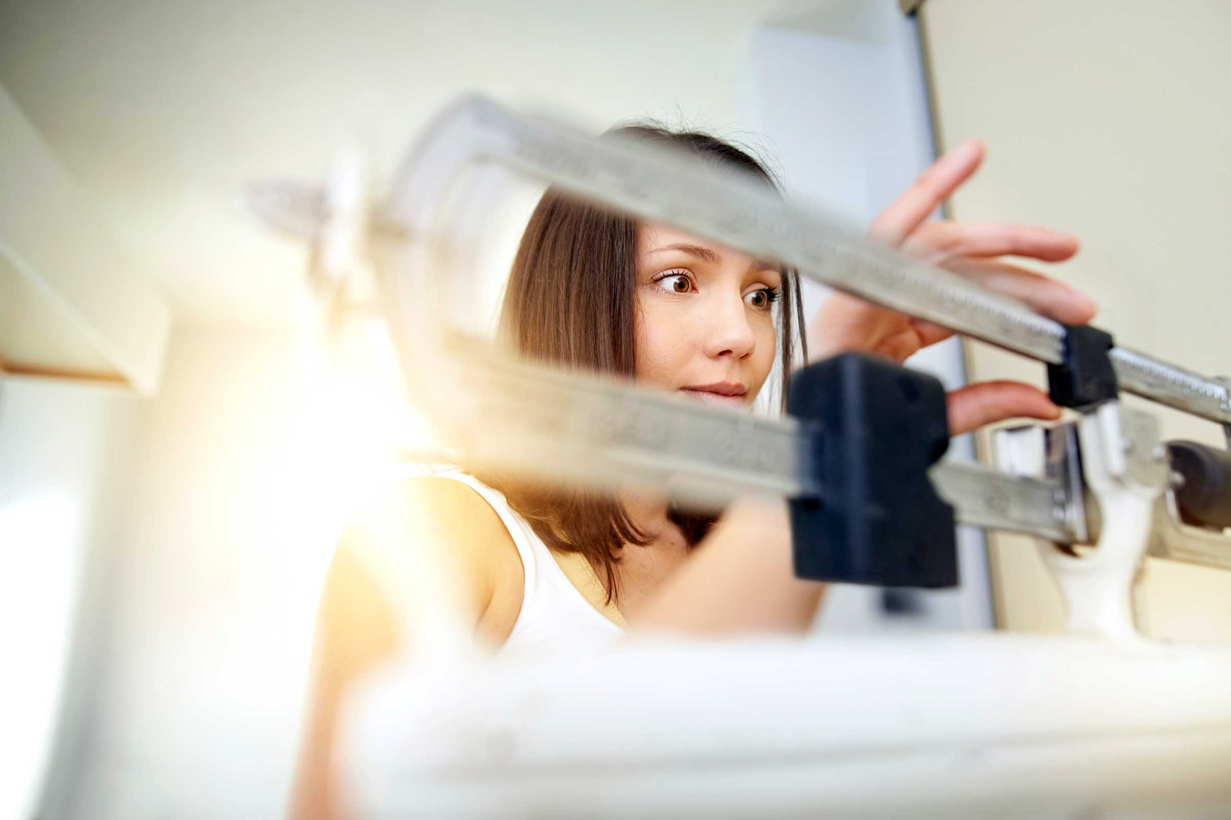woman moving weights on a scale