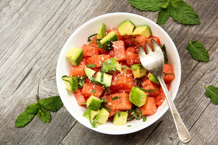 Bowl of watermelon, basil and avocados.