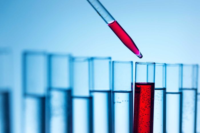 test tubes with liquid; dropper putting red fluid into one test tube