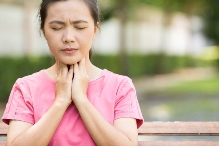 Woman in pain touching her neck.