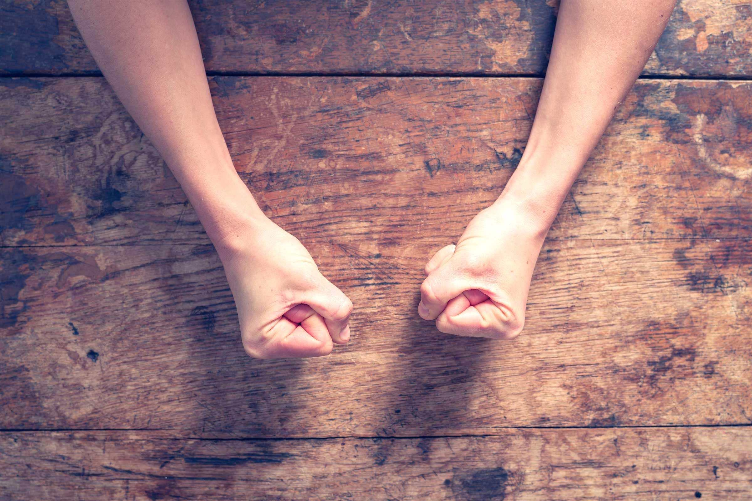 two fists on a wooden table