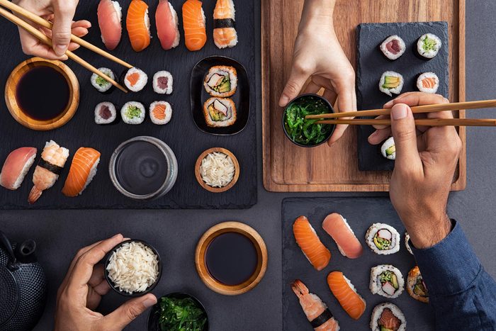 People eating sushi at a restaurant.