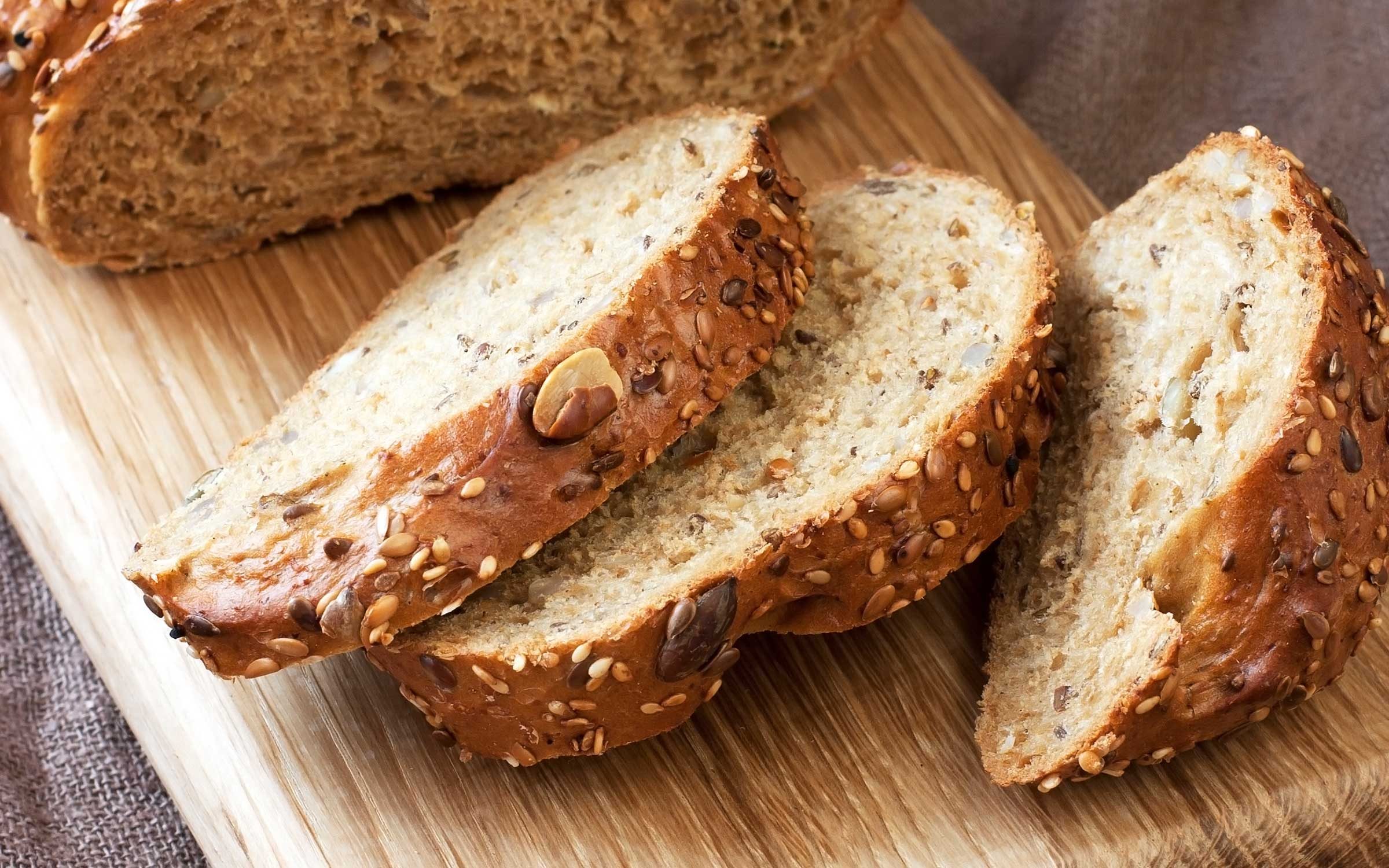 three slices cut from brown bread on wooden board
