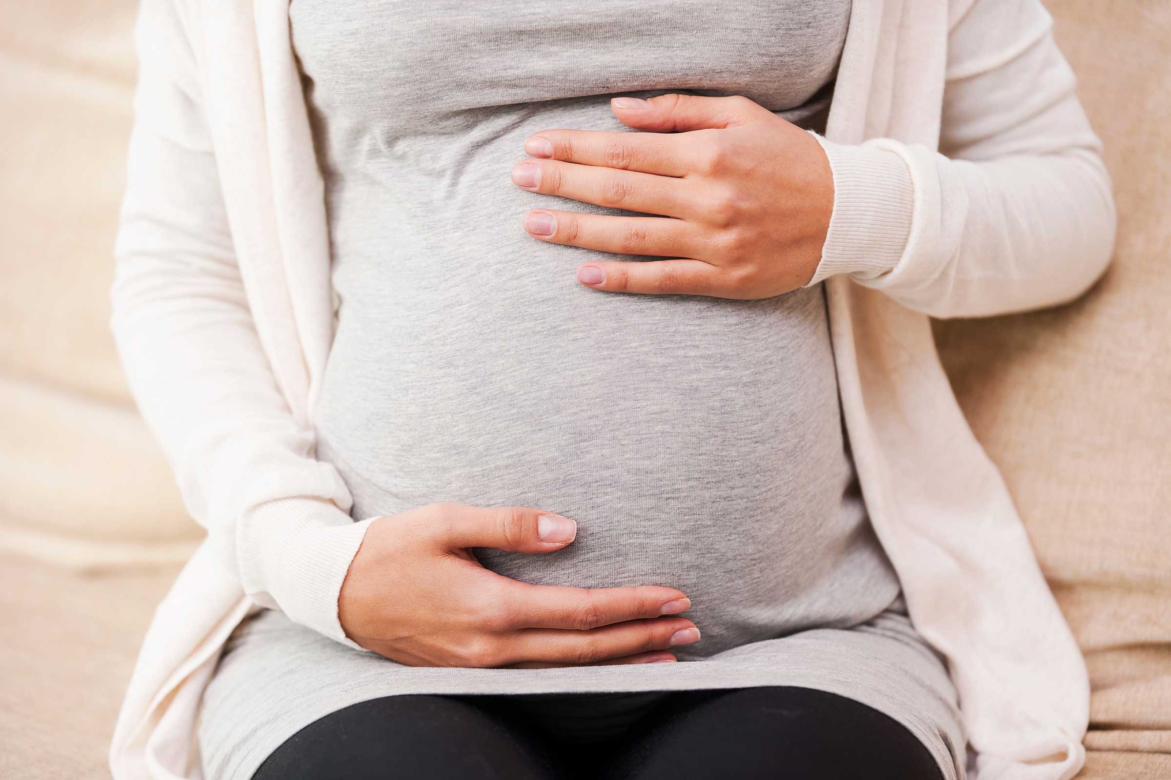 Pregnant woman holding her belly.