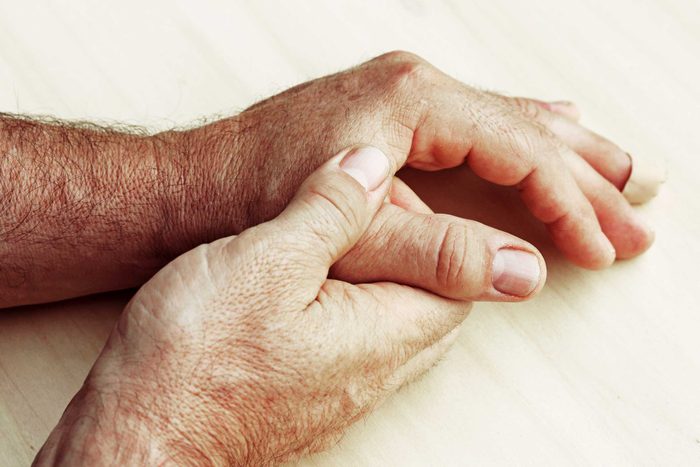 man massaging his thumb joint