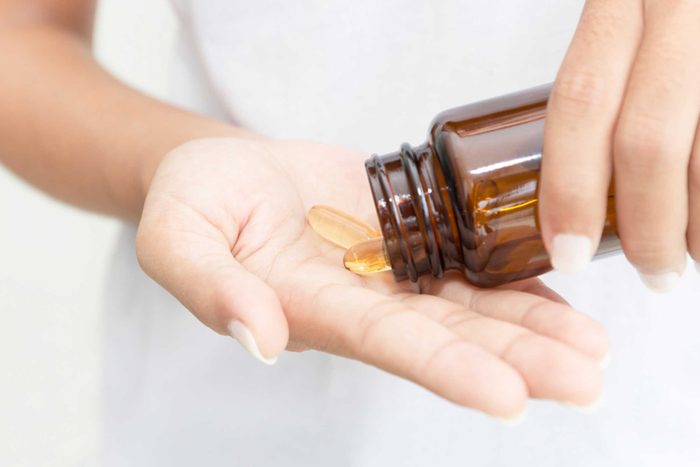 Woman holding supplements in hand