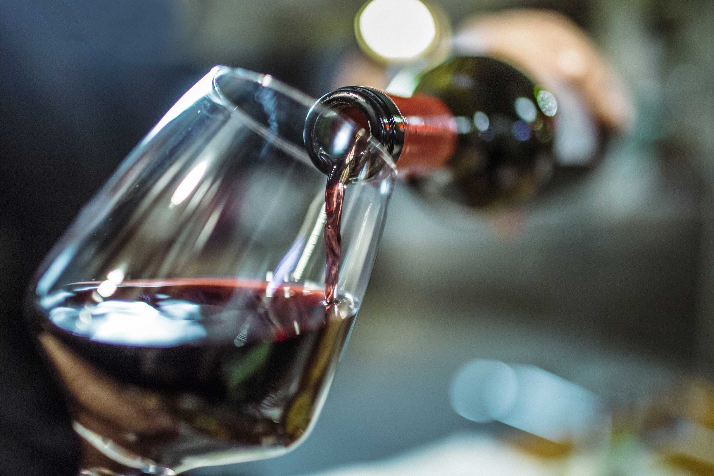 bottle of red wine pouring into a wine glass