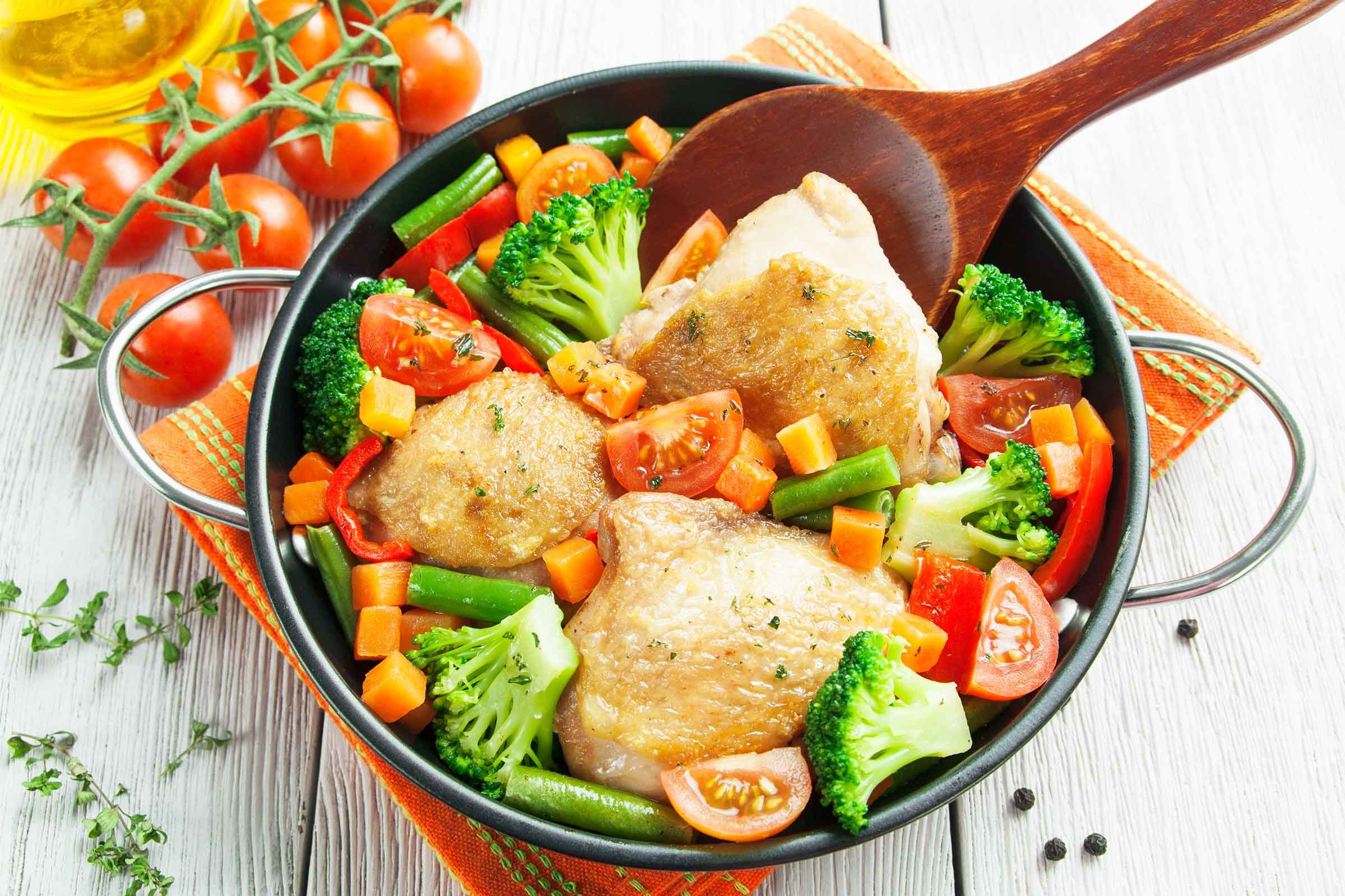 Chicken with broccoli, carrots and tomatoes in a casserole dish