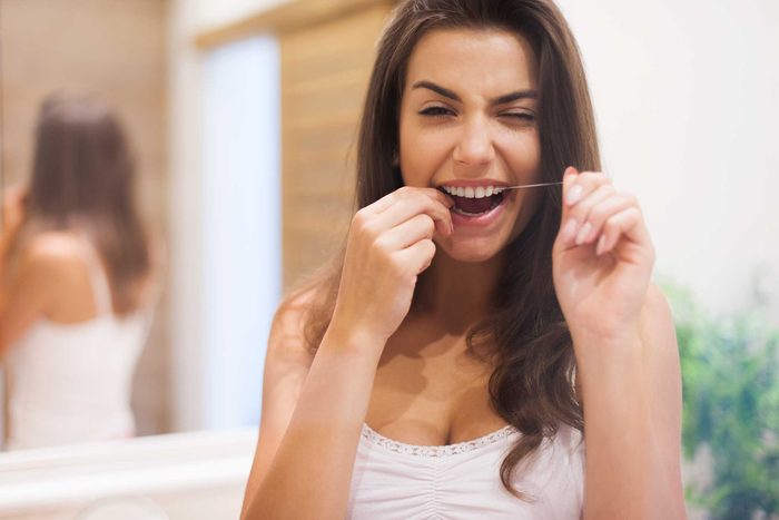 woman flossing teeth