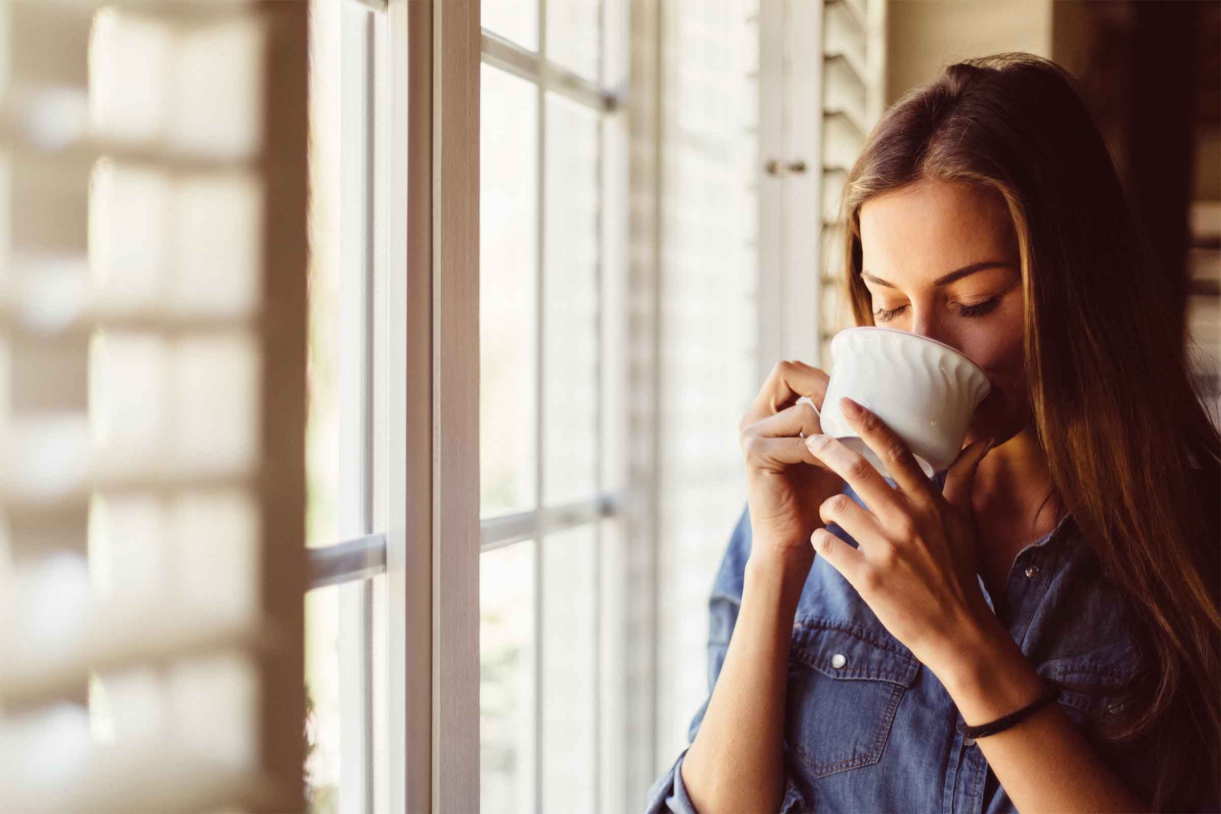 woman drinking tea by a window