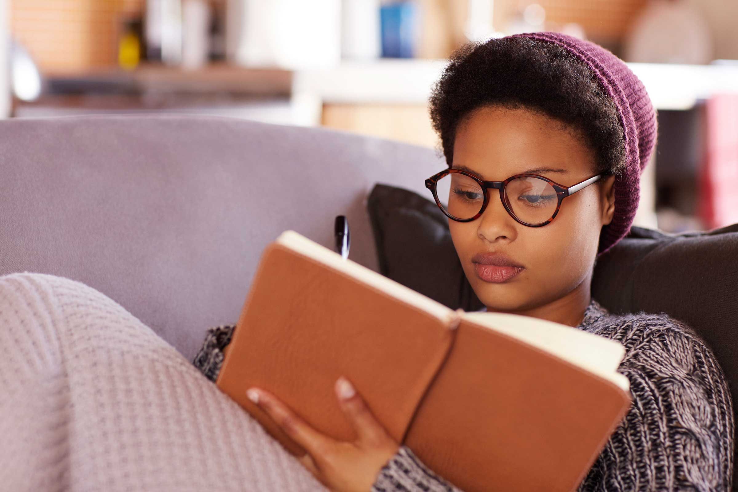 woman reading a book on a couch