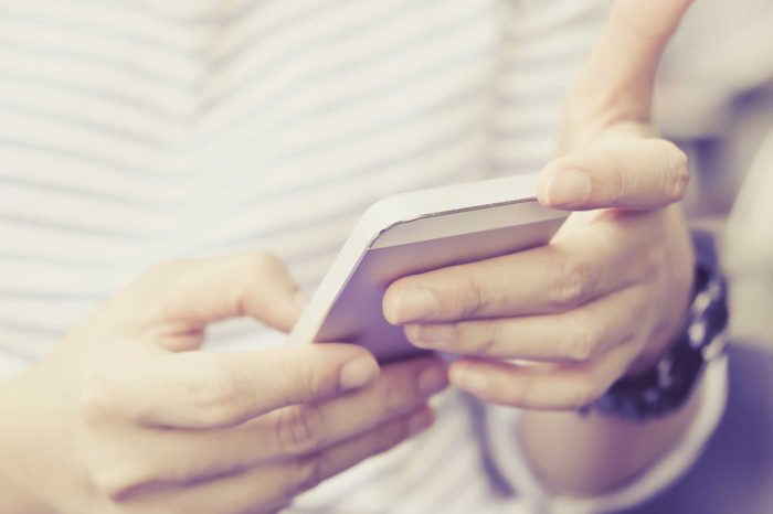 Person in a striped shirt using their smartphone.