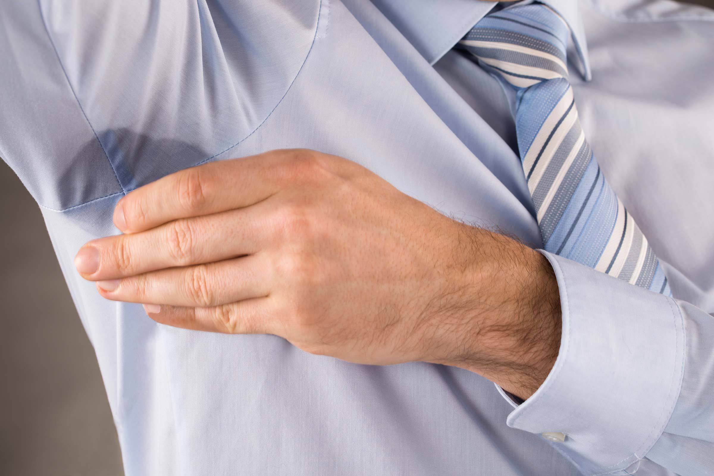 Man's shirt shows underarm sweat.