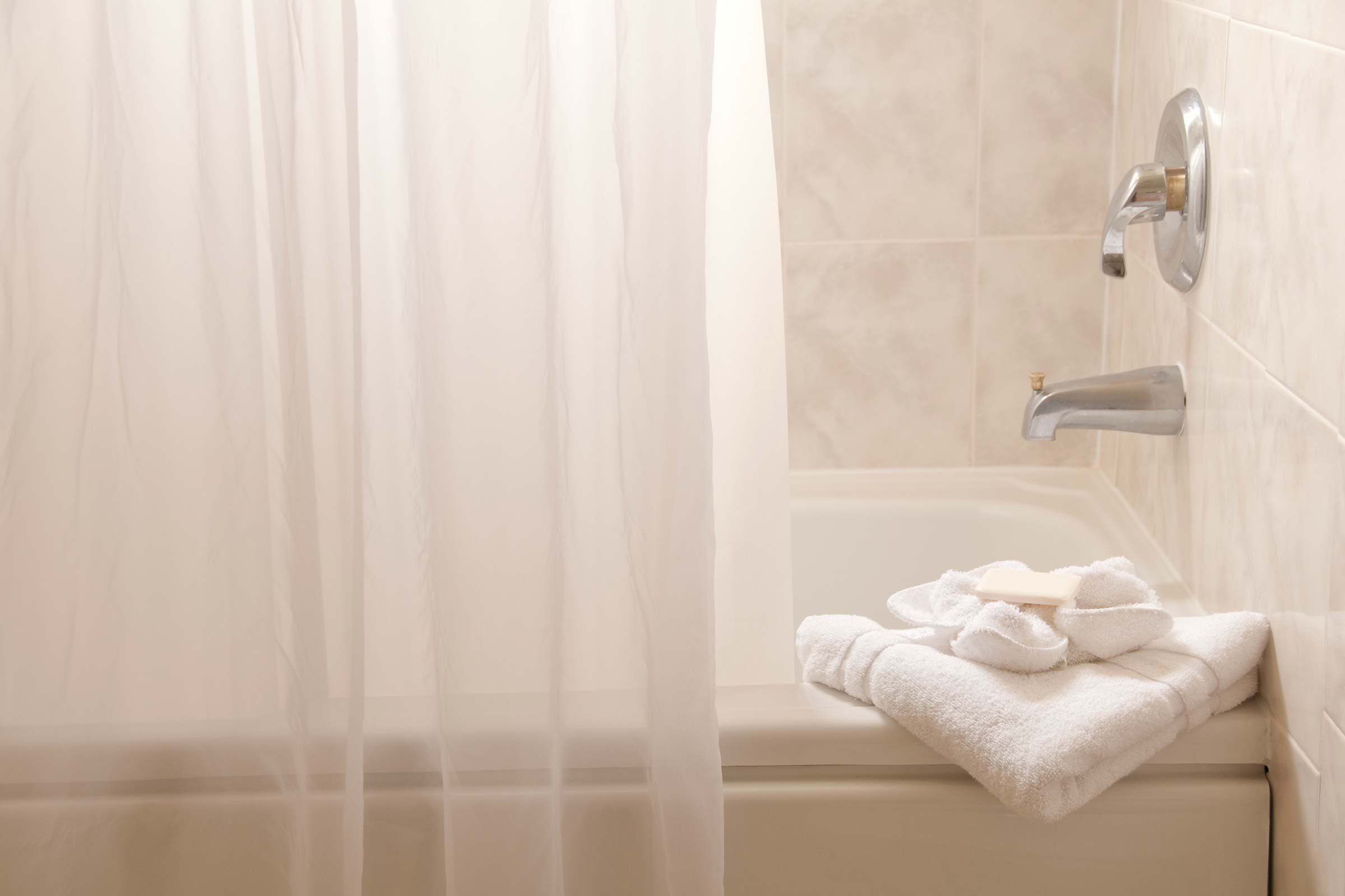 Bathtub with shower curtain.