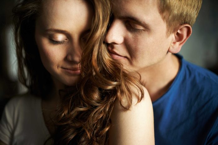 man embracing a woman from behind
