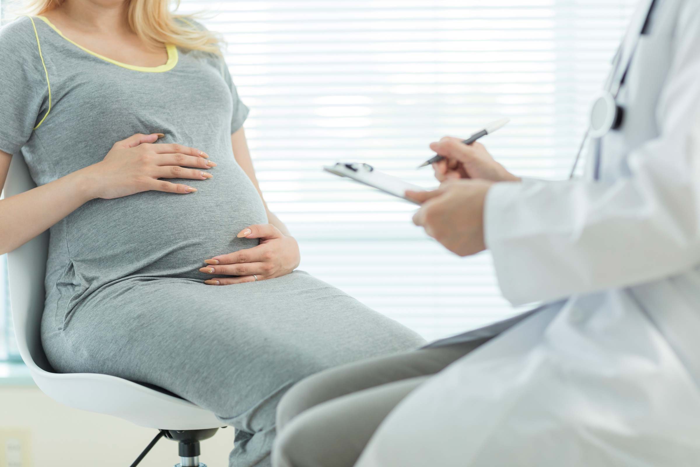 pregnant woman speaking with a doctor