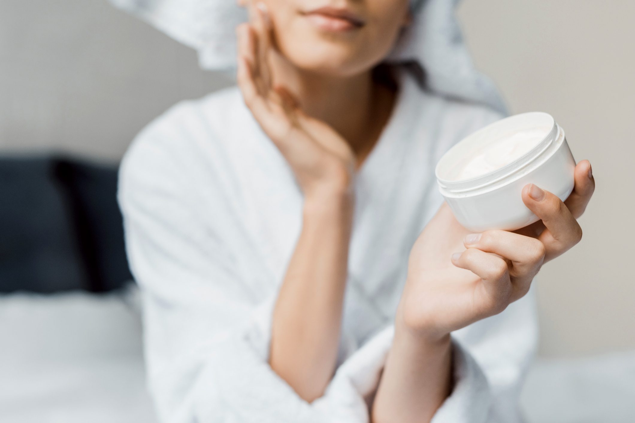woman applying cream on face