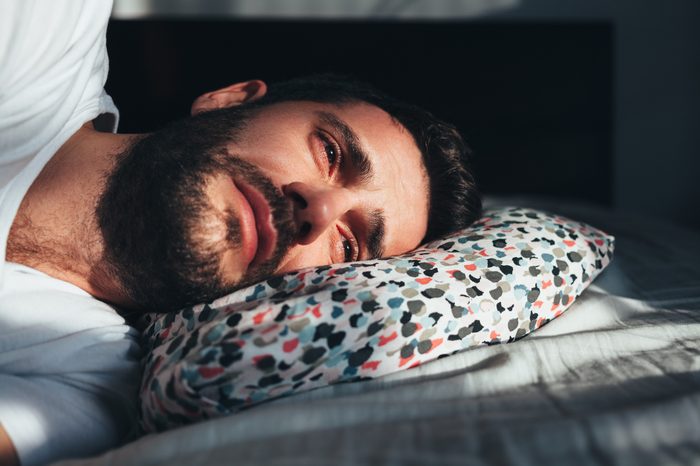 young man crying alone in bed