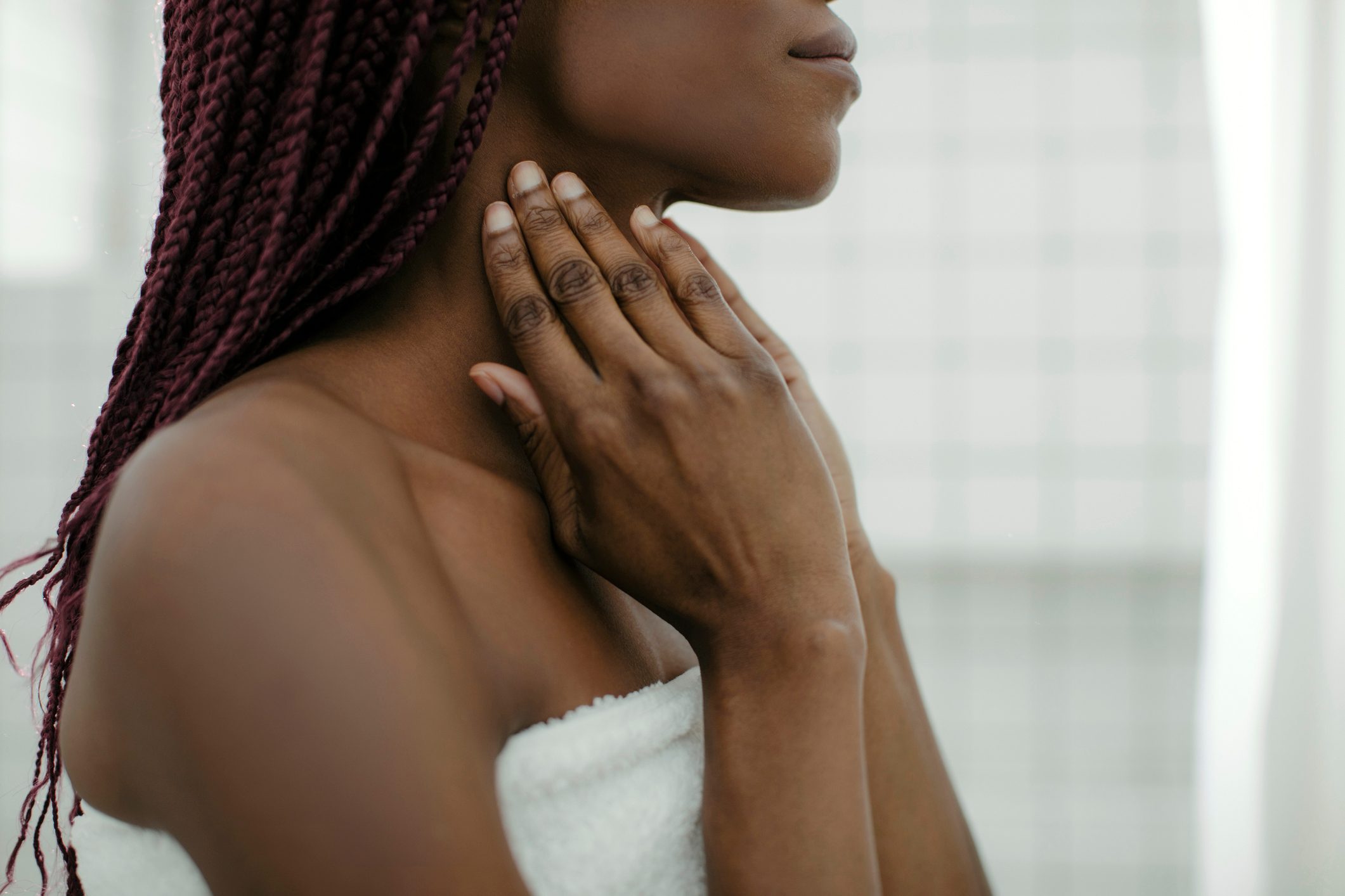 woman applying lotion to neck