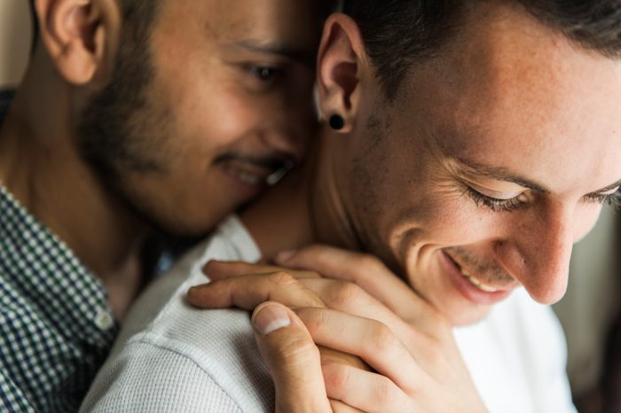 gay couple embracing at home