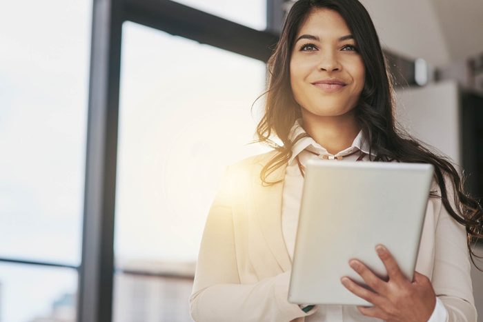 Smiling woman holding computer tablet.