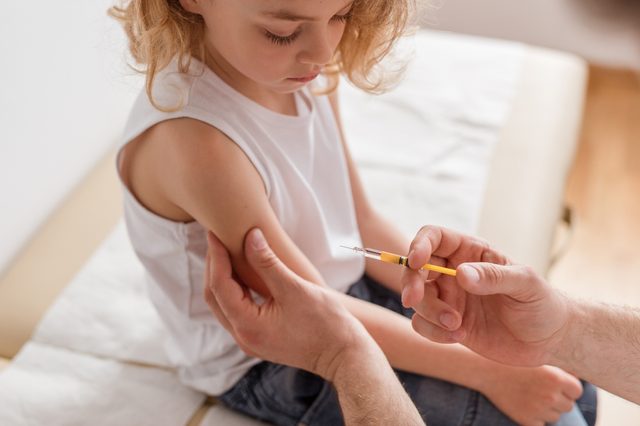 doctor giving a young girl a vaccination