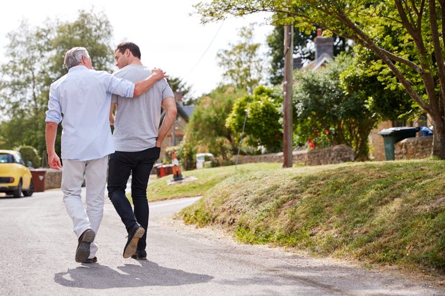 rear view of two men walking and talking