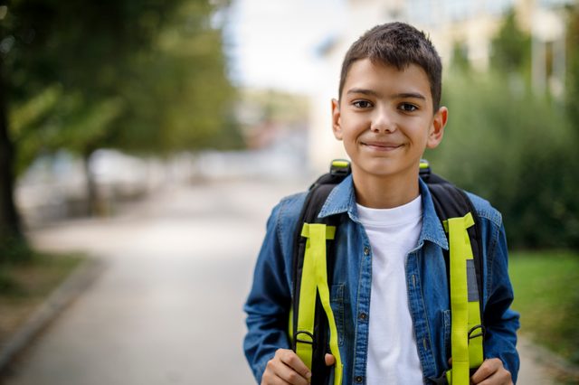 happy young boy walking home from school