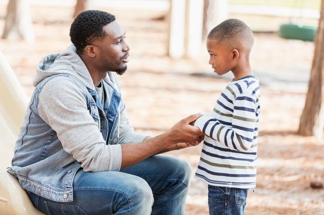 father talking to his son on the playground