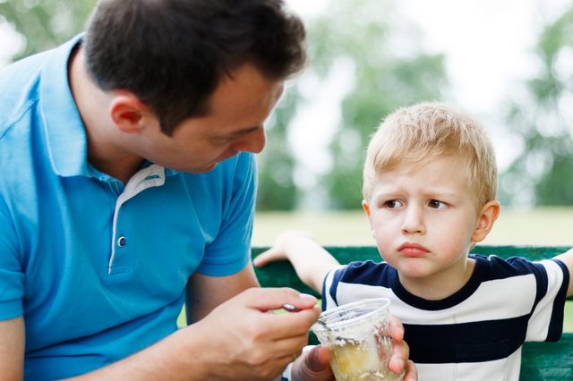 father trying to get his young son to eat