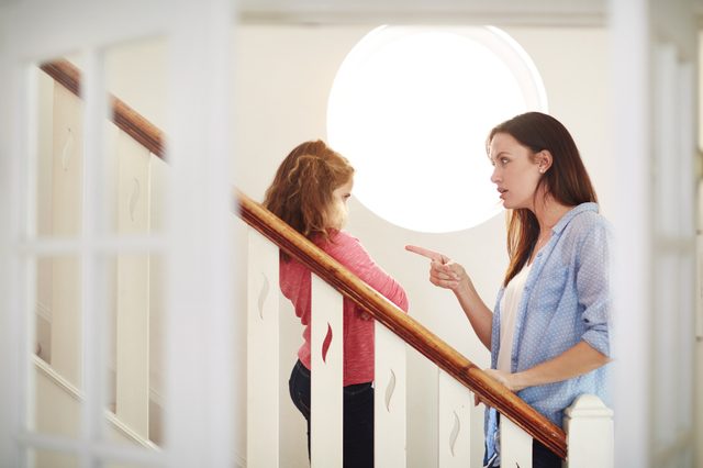 mother disciplining young daughter at home