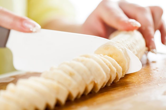 Woman slicing a banana.