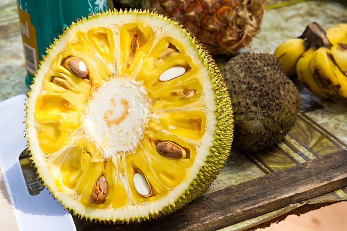 Half of a jackfruit, sliced through the middle.