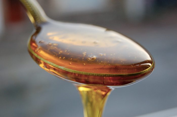 close up of syrup dripping off of a spoon