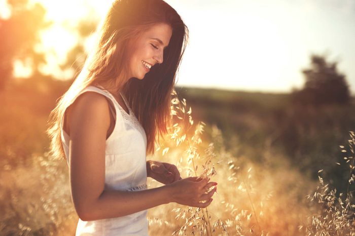 Woman in field at sunset