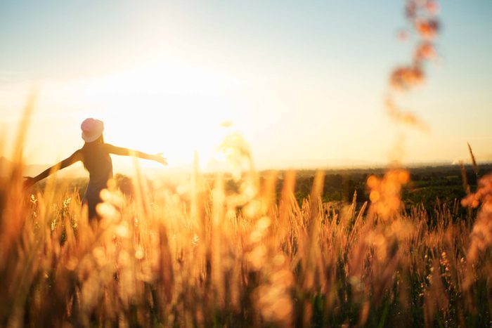 woman in a field during sunset