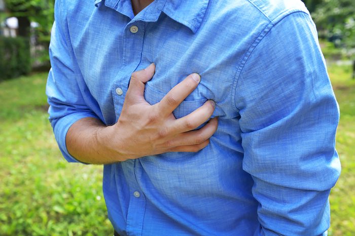 man clutching his chest inpain