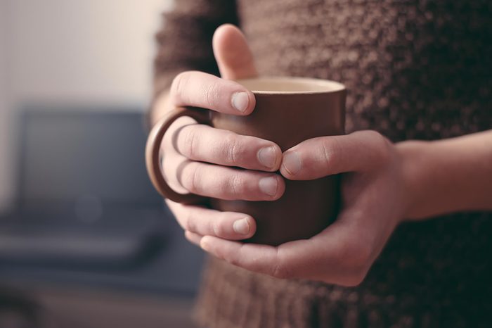 holding cup of coffee